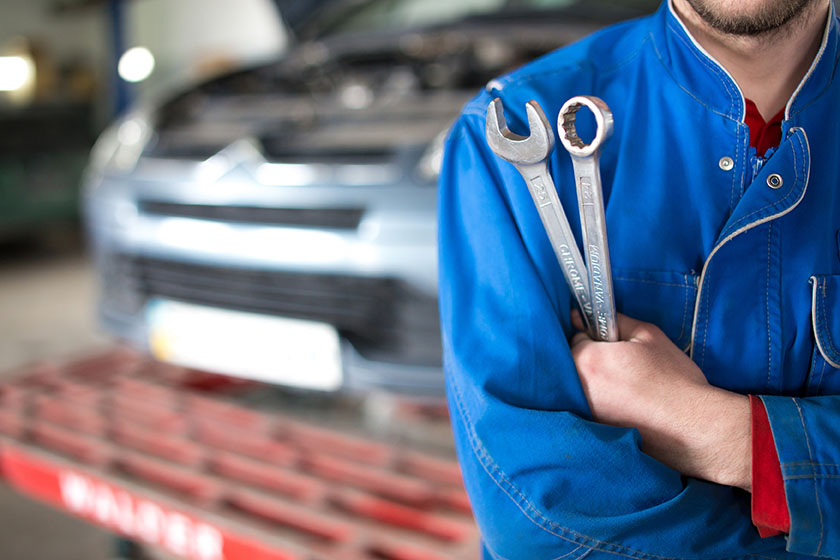 Hand of car mechanic with wrench. Auto repair garage.